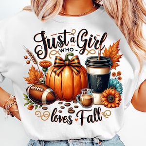 May include: White t-shirt with a fall-themed graphic. The design includes a pumpkin, football, coffee cup, and the text "Just a Girl who loves Fall". The image is surrounded by fall foliage and flowers.