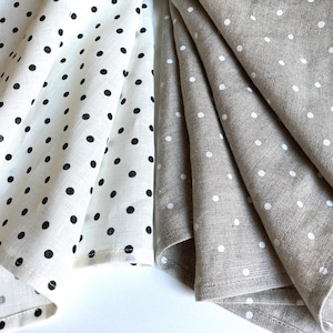 May include: Set of folded linen tea towels with polka dot patterns. One set is white with black polka dots, the other is beige with white polka dots.