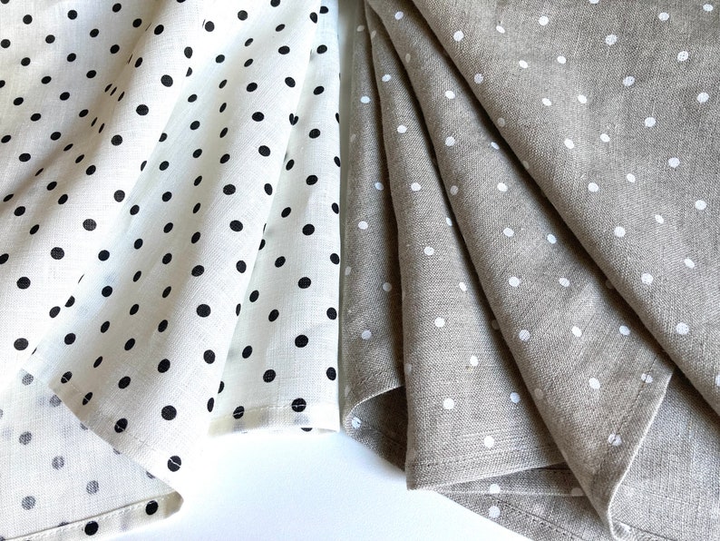May include: Set of folded linen tea towels with polka dot patterns. One set is white with black polka dots, the other is beige with white polka dots.