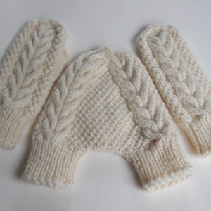 K&ouml;nnte beinhalten: Ein Paar wei&szlig;e Strickhandschuhe mit einem Zopfmuster. Die Handschuhe sind durch eine Strickband verbunden.