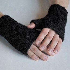 May include: A pair of black fingerless gloves with a cable knit pattern.