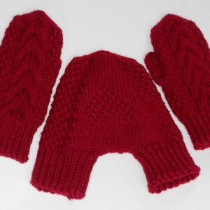 K&ouml;nnte beinhalten: Ein Set aus roten Strickhandschuhen und einer passenden M&uuml;tze. Die Handschuhe haben ein Zopfmuster und die M&uuml;tze ist ein einfacher Strick.