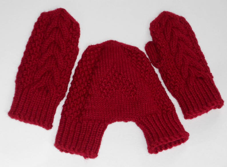 K&ouml;nnte beinhalten: Ein Set aus roten Strickhandschuhen und einer passenden M&uuml;tze. Die Handschuhe haben ein Zopfmuster und die M&uuml;tze ist ein einfacher Strick.