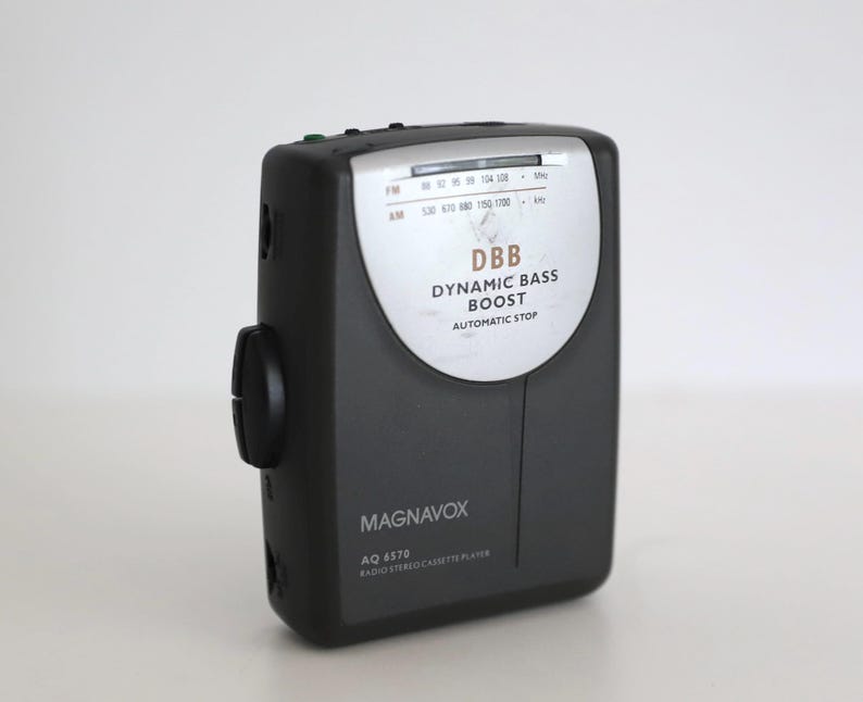 Puede incluir: Un reproductor de radio y casetes Magnavox AQ 6570 negro y plateado con funci&oacute;n DBB Dynamic Bass Boost y parada autom&aacute;tica. La radio tiene un dial con frecuencias FM y AM.
