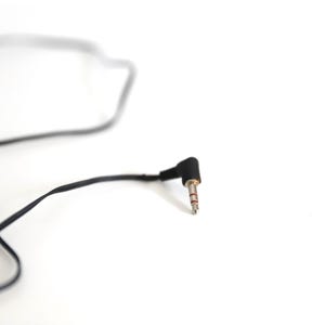 Puede incluir: Un cable de audio negro con un conector jack de 3,5 mm. El cable est&aacute; enrollado y el conector est&aacute; en &aacute;ngulo.