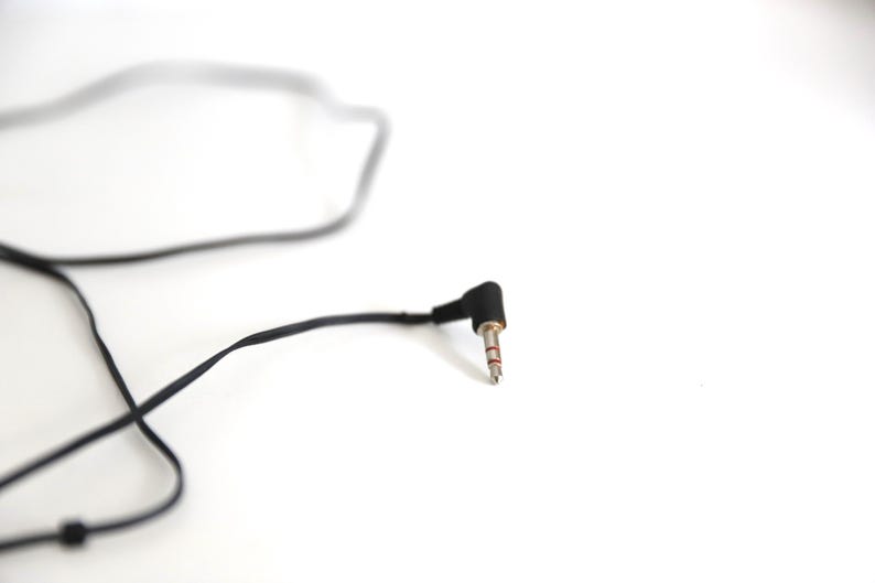 Puede incluir: Un cable de audio negro con un conector jack de 3,5 mm. El cable est&aacute; enrollado y el conector est&aacute; en &aacute;ngulo.