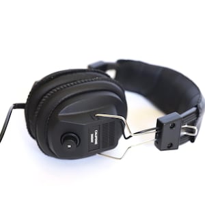 May include: Black over-ear headphones with a padded headband and earcups. The headphones have a silver metal frame and a black cord. The model name "CALIFONE 3060AV" is printed on the side of the earcup.
