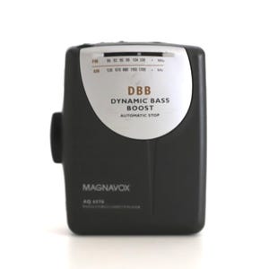 Puede incluir: Un reproductor de casetes port&aacute;til negro y plateado con el texto "DBB Dynamic Bass Boost Automatic Stop" y "MAGNAVOX AQ 1570" en la parte delantera.