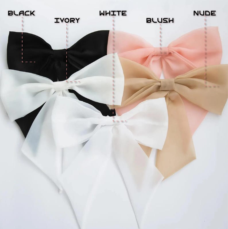 May include: A collection of large, elegant bows in various colors, including black, ivory, white, blush, and nude. Each bow is made of a delicate, sheer fabric and features a decorative center.