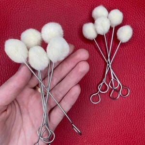 Pode incluir: Um conjunto de 10 aplicadores de lã branca em cabos de metal. Os aplicadores são usados para aplicar tinta, tinta ou outros materiais.