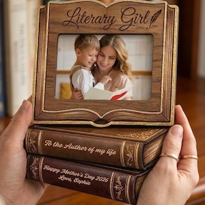 Peut inclure: Une tasse en céramique blanche avec une anse noire et le texte "But First, Coffee" en gras noir. La tasse contient un liquide foncé, probablement du café, et repose sur une surface claire.