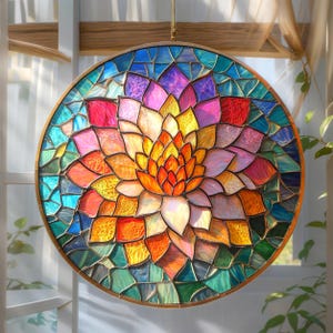May include: A round stained glass window with a floral design. The window features a vibrant array of colors, including orange, yellow, pink, blue, and green. The glass is set in a gold-colored metal frame, creating a decorative piece for home decor.