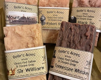 May include: Five rectangular bars of Belle's Acres artisan grass fed tallow and cream soap. The labels feature names including Mountain Man, Robert, Black Tie, Sir William, and Tennessee Whiskey, with illustrations of a crown, bottle, and suit.