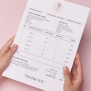 Puede incluir: Una factura blanca con texto negro es sostenida por manos sobre un fondo rosa. La factura incluye campos para información de la empresa y del cliente, detalles del producto y métodos de pago. Un diseño floral está en la parte superior.