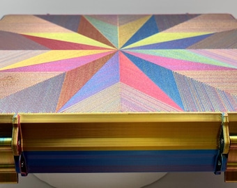 May include: A colorful, geometric patterned box with a gold trim and blue base. The box has two latches on the front.