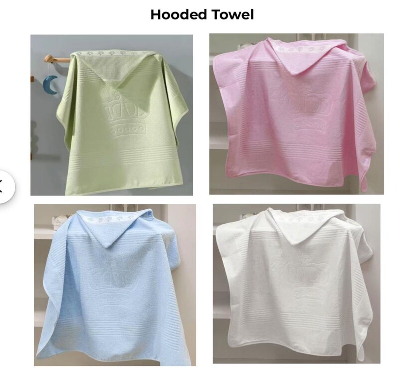 Op de afbeelding: Vier badhanddoeken met capuchon in verschillende kleuren: groen, roze, lichtblauw en wit. De groene handdoek heeft een wit kroonontwerp. De handdoeken hangen aan een rek.