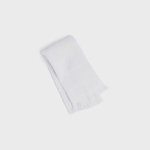 May include: A solid white rectangular towel featuring a soft, woven fabric texture. The towel is folded neatly and displays a decorative horizontal band across the center, finished with short, delicate fringe detailing along the bottom edge.