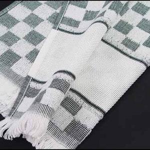 May include: White kitchen towel with a green and white checkered pattern. The towel has a fringe border.