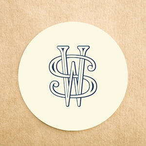 May include: A white round coaster with a blue monogram of the letters "W" and "S" intertwined.