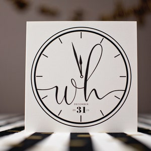 May include: A black and white clock face with roman numerals and a stylized 'wh' in the center. The clock hands point to midnight and the text 'DECEMBER 31 20 21' is below the clock face.