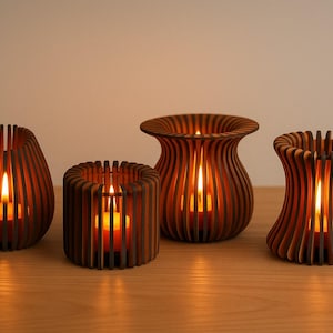 Op de afbeelding: Vier houten kandelaars in een warme bruine kleur. Elke houder heeft een unieke vorm met verticale lamellen, waardoor het kaarslicht doorschijnt. De brandende kaarsen creëren een gezellige sfeer.