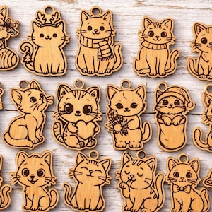 May include: A collection of wooden cat ornaments with various designs. Each ornament is a light brown color and features a different cat illustration, some with festive accessories like scarves, hats, and a Santa stocking. The ornaments have a small hole at the top for hanging.