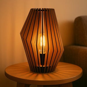 May include: A wooden geometric table lamp with a warm glow. The lamp has a series of vertical wooden slats that form a shade around a central light bulb. The lamp sits on a small, round wooden table.