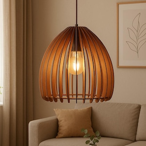 Op de afbeelding: Een houten hanglamp met een warme gloed. De lamp heeft een bruine, lattenkap die een zichtbare gloeilamp omringt. De lamp hangt aan een donkerbruin snoer, wat een moderne, stijlvolle uitstraling creëert.