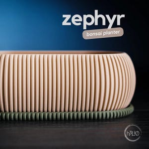 May include: A light beige bonsai planter with a ribbed design and a dark green rim. The planter is labelled "zephyr bonsai planter".