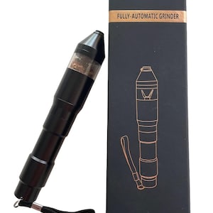 Puede incluir: Molinillo totalmente automático negro con una sección superior transparente, junto a una caja negra con el texto "FULLY-AUTOMATIC GRINDER". El molinillo tiene una correa de muñeca adjunta. La caja tiene un dibujo lineal del molinillo.