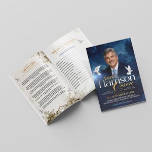 Könnte beinhalten: Ein Trauerprogramm-Heft mit einem dunkelblauen Einband, einem Porträt von James Harrison, weißen Tauben und Text zum Gottesdienst. Die aufgeschlagenen Innenseiten zeigen einen Nachruf und den Ablauf der Trauerfeier mit floralen Akzenten.