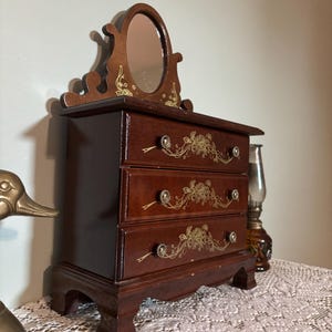 Joyero vintage de madera con espejo, estilo cómoda de tres cajones, con forro rosa, decoración de tocador estilo cottagecore.