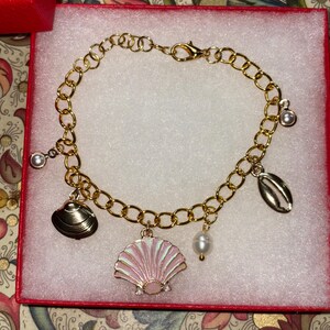 Unique gold charm bracelet, sea shell themed with adjustable sizing.