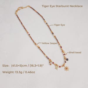 May include: A Tiger Eye Starburst Necklace featuring Tiger Eye, Yellow Jasper, and shell beads. The necklace includes gold-toned star and sun charms. The text indicates a size of (41.5+5) cm / (16.3+1.9) inches and a weight of 13.3g / 0.46oz.