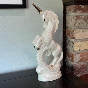 Estatua de unicornio perlado de pie, con cuerno y pezuñas doradas