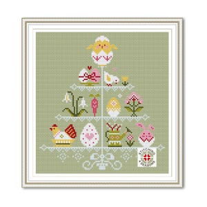 May include: A cross-stitch pattern featuring a tiered stand decorated with Easter eggs, chicks, flowers, and a bunny. The stand is on a green background with the text "Stitching 4 Seasons".