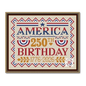 May include: A framed cross-stitch design celebrating America's 250th birthday. The design features the word "AMERICA" in blue, "250th BIRTHDAY" in gold and red, and the years "1776-2026". The border is a red, white, and blue zig-zag pattern.