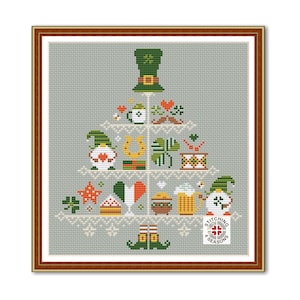 Può includere: Schema a punto croce con un design ad albero per la festa di San Patrizio. L'albero è composto da simboli irlandesi, tra cui un cappello da folletto, trifogli, un ferro di cavallo e una pinta di birra. Lo sfondo è grigio chiaro.