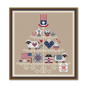 May include: Cross-stitch artwork in a brown frame, featuring a patriotic tree design. The tree is adorned with American flags, stars, hearts, and sheep, all in red, white, and blue. The artwork is set against a beige background.
