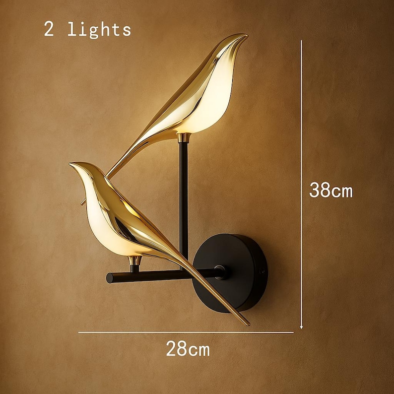 May include: Gold bird-shaped wall sconces with black metal accents. The sconces are mounted on a wall and feature two lights. The sconces are 28 inches wide and 38 inches tall. 2 lights.
