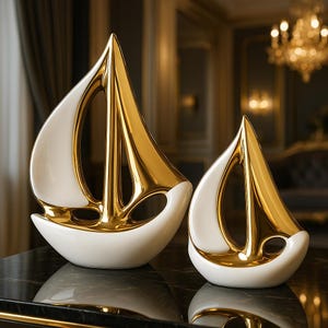 May include: Two white ceramic sailboats with gold accents. The larger sailboat is in the foreground and the smaller sailboat is in the background.