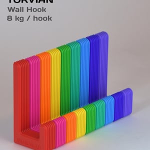 Könnte beinhalten: Ein Torvian Wandhaken mit einem regenbogenfarbenen, gerippten L-förmigen Design. Der Text lautet: TORVIAN Wall Hook 8 kg / hook. Mounting included adhesive mount or screws + wall plugs. Der Haken verfügt über eine vertikale Rückseite.