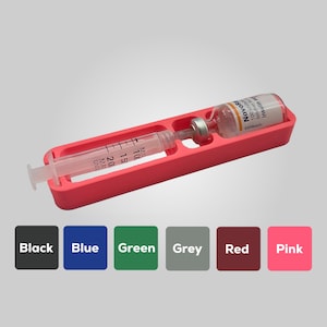 May include: A vibrant pink medical tray containing a syringe and a medication vial. The syringe is transparent with black unit markings. The vial has a white label with the text "NovoR" and "Insulin". Colour options are shown below the tray.