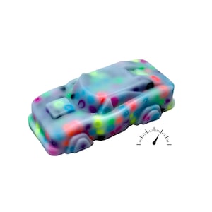 May include: A toy car with a light blue body and multi-coloured polka dots. The car has a speedometer graphic next to it. The toy car is a fun and playful item.