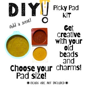 Puede incluir: Imagen de un kit Picky Pad DIY. El texto incluye "DIY", "¡Añade un aroma!", "Kit Picky Pad", "¡Sé creativo con tus cuentas y abalorios viejos!" y "¡Elige el tamaño de tu almohadilla!". Se muestran tres almohadillas de diferentes colores.