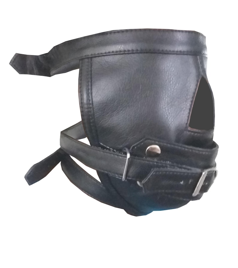 Op de afbeelding: Zwarte leren muilkorf met een gebogen ontwerp en een open gedeelte voor de neus. De muilkorf heeft verstelbare riemen met metalen gespen en een drukknoopsluiting. Het product is ontworpen om rond de snuit te passen.