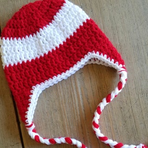 Peut inclure: Chapeau crocheté rayé rouge et blanc avec un long cordon tressé.