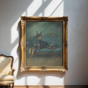 May include: A framed painting of a Doberman Pinscher dog resting on a teal blue sofa. The dog is black and tan, with a regal pose. The ornate gold frame adds a vintage aesthetic to the artwork, which is mounted on a white wall.