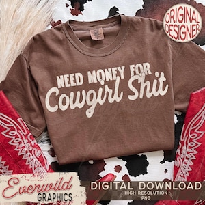 Könnte beinhalten: Ein braunes T-Shirt mit dem weißen Text "NEED MONEY FOR Cowgirl Shit". Das Shirt wird auf einer Oberfläche mit Kuhfellmuster präsentiert, mit roten Cowboy-Stiefeln. Das Bild enthält den Text "Everwild Graphics" und "Digital Download".