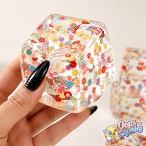 Può includere: Un giocattolo squishy trasparente a forma di cubo riempito con decorazioni in miniatura a forma di fettine di frutta colorate, tra cui fragole, limoni, lime e arance. Il materiale trasparente rende visibili i motivi della frutta su ogni lato.